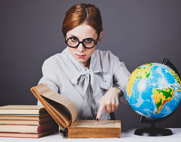 a fiatal tanár, szemüveg, a könyvek és a globe. - Fotó, kép