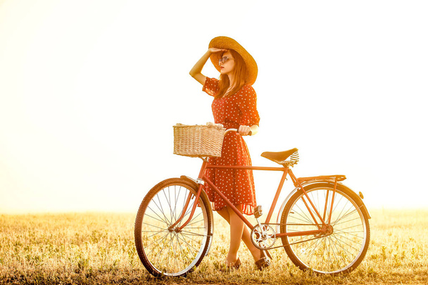 Girl on a bike in the countryside in sunrise time - Photo, Image