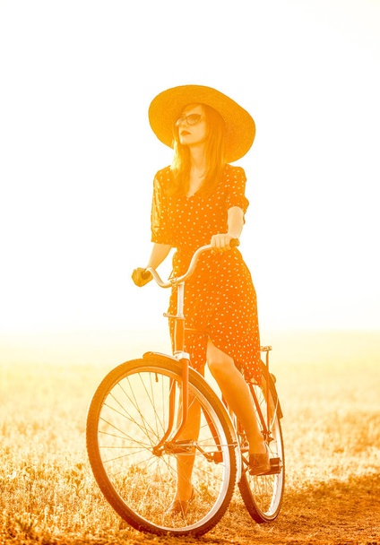 Дівчина на велосипеді в сільській місцевості під час сходу сонця
 - Фото, зображення