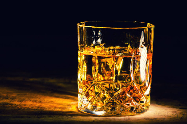whiskey with ice cubes on wooden background - Foto, afbeelding