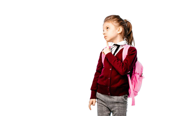 Child with schoolbag. Girl in white shirt and gray pants, hold a school bag and posing like model. Isolated on white - Valokuva, kuva