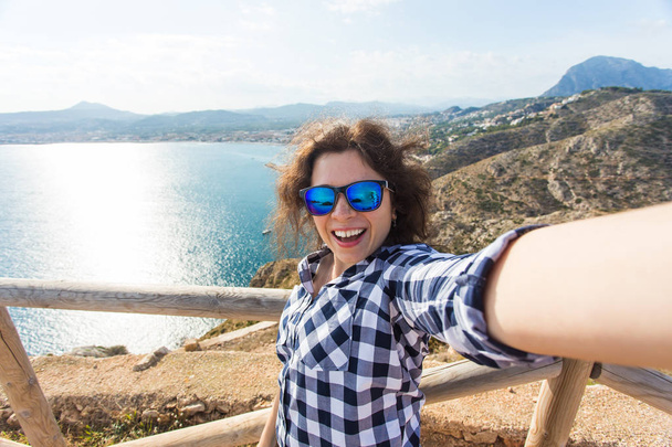 Vakantie-, vakantie- en reisinformatie concept - Happy jonge vrouw selfie overname prachtige landschap - Foto, afbeelding