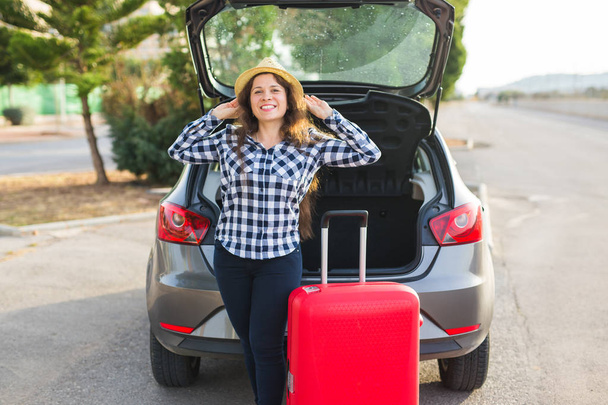 幸福と旅行人コンセプト - 笑顔に行く準備車背面近くに立っている若い女性。夏の遠征 - 写真・画像