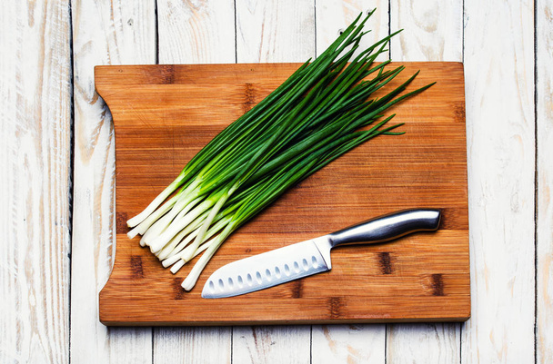 Fresh green onions on a cutting board - Foto, afbeelding