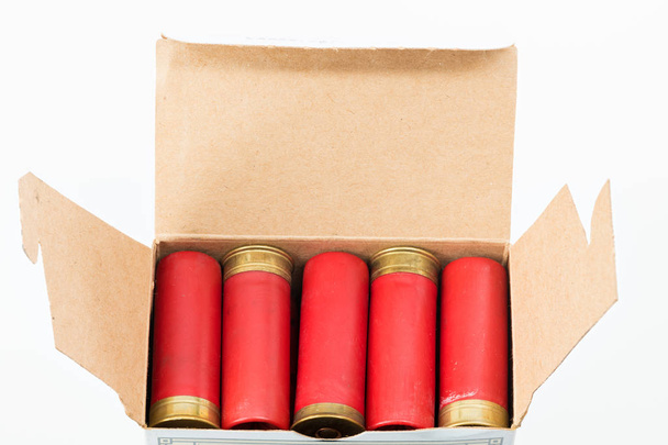 Красные патроны дробовика 12 калибра загружены в картонную коробку
 - Фото, изображение