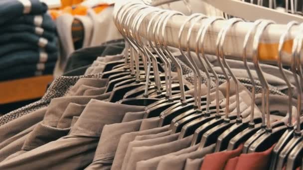 Reihe verschiedener modischer Herrenhemden auf einem riesigen Kleiderbügel im Herrenbekleidungsgeschäft im Einkaufszentrum. - Filmmaterial, Video