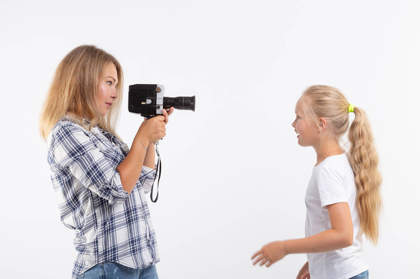 Φωτογραφία, φωτογράφος και ρετρό έννοια κάμερα - νεαρή γυναίκα χρησιμοποιώντας vintage φωτογραφική μηχανή σε λευκό φόντο - Φωτογραφία, εικόνα