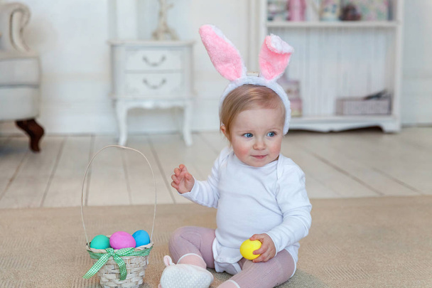 Kis gyermek lány visel nyuszi füle, húsvét napján, és játék-val festett tojások - Fotó, kép