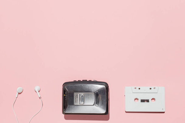 White audio cassette and cassette pleer with headphones on a pink background. Party 90s concept - Foto, Bild
