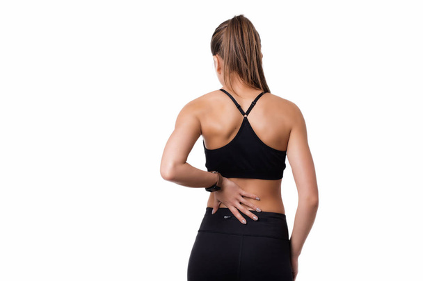 Ból pleców. Athletic kobieta działa z urazów kręgosłupa w sportowej tarcie, dotykając dolnej mięśnie pleców. - Zdjęcie, obraz