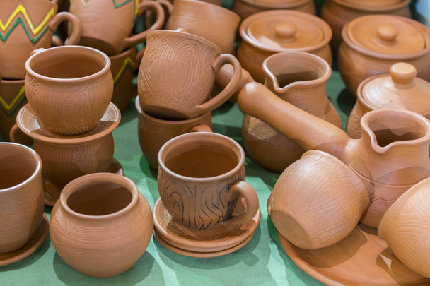Lots of traditional ukrainian handmade clay pottery production. brown pottery. Clay plates and cups - Photo, Image