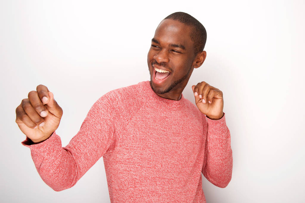 Porträt eines modischen jungen schwarzen Mannes, der lächelt und tanzt - Foto, Bild