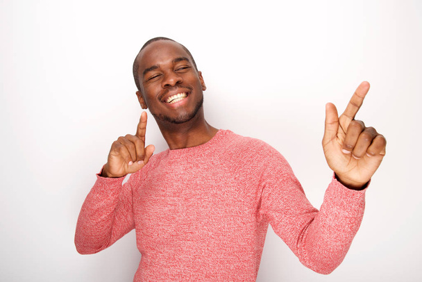 Portrait of handsome young fun black man dancing against white background - Photo, Image