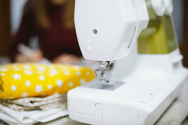 Máquina de coser con muchos materiales de costura, sobre una mesa de madera
  - Foto, Imagen