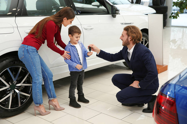 Car salesman working with family in dealership - Photo, Image