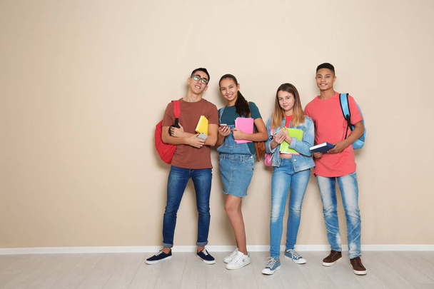 Skupina teenagerů proti barevné zdi, prostor pro text. Životní styl mládeže a přátelství - Fotografie, Obrázek