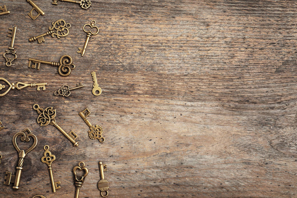 Old vintage keys on wooden background, flat lay. Space for text - Φωτογραφία, εικόνα