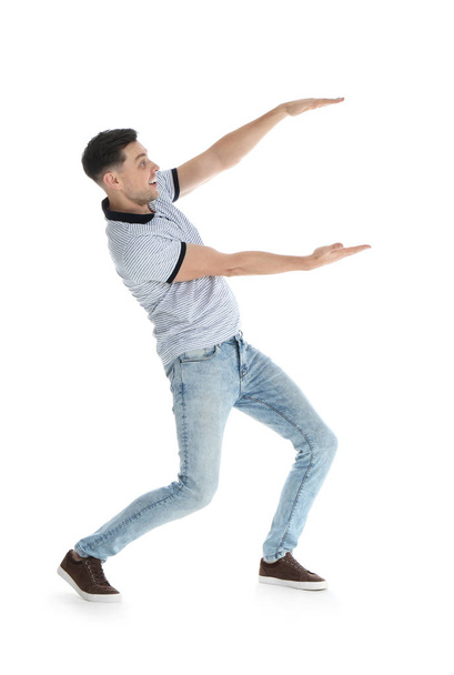 Man in casual clothes holding something on white background - Fotó, kép
