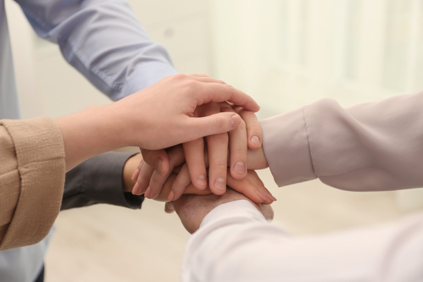 Group of people holding their hands together on blurred background, closeup - Photo, Image