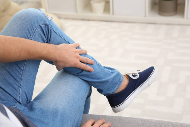Man suffering from leg pain at home, closeup - Фото, зображення