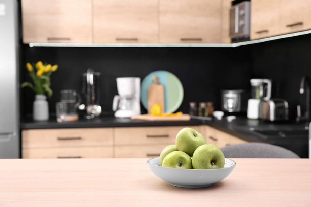 Tazón de fruta con manzanas en la mesa en la cocina, enfoque selectivo
 - Foto, imagen