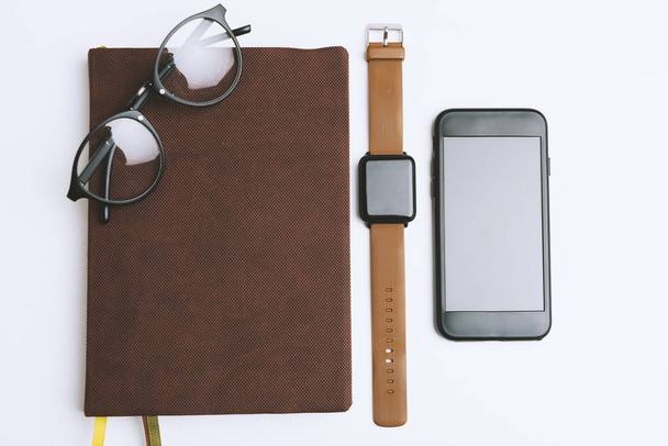 Minimalist iş yerinde defter, gözlük, smartwatch ve akıllı telefon ile - Fotoğraf, Görsel