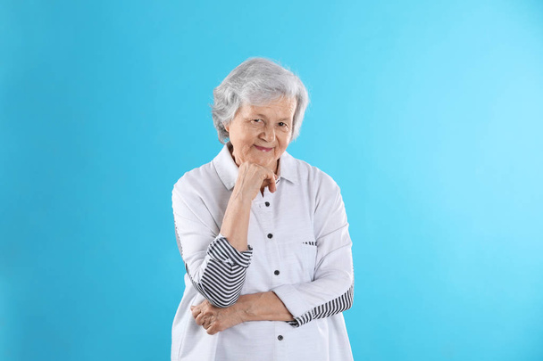 Portrait of grandmother in stylish clothes on color background - Foto, Imagen