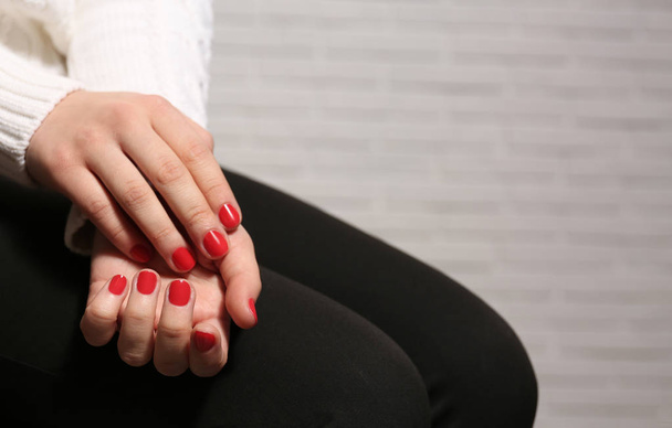 Woman with red manicure on blurred background, space for text. Nail polish trends - Foto, afbeelding