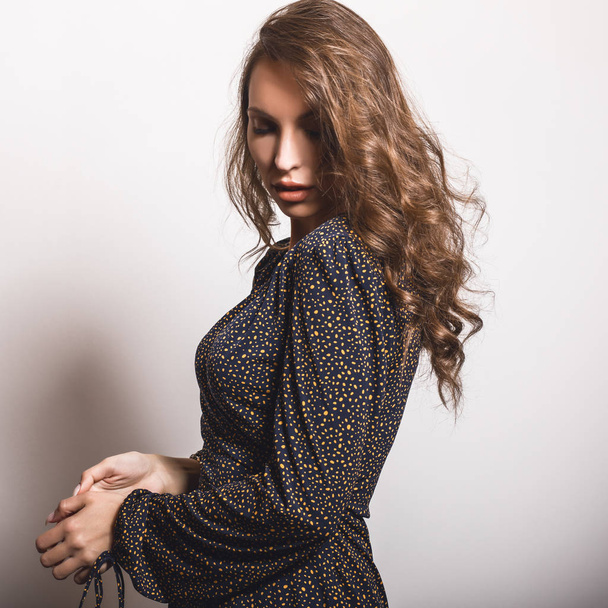 Beautiful girl in stylish dress posing in studio. - Photo, image