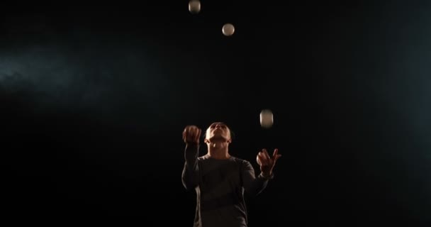 Zirkusartistin jongliert auf der schwarzen Bühne. - Filmmaterial, Video