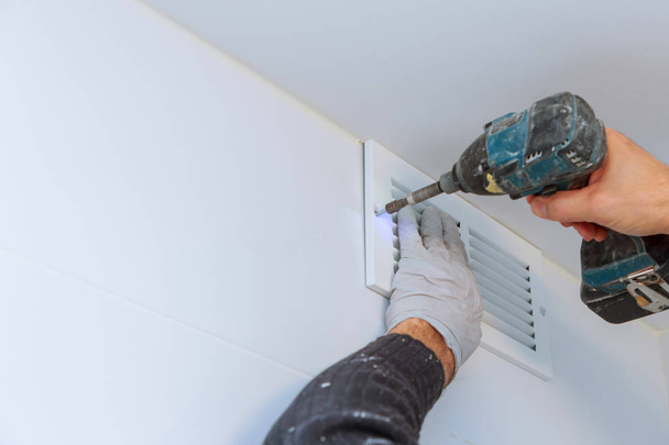 Close up man hand installing vent cover from ceiling - Φωτογραφία, εικόνα