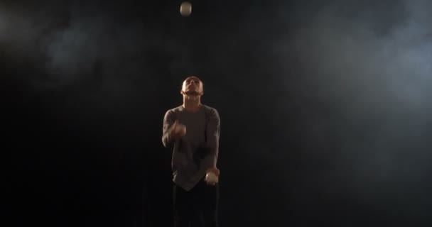 Žonglér na jevišti dělá triky se 7 kuličkem-4k pomalý pohyb. - Záběry, video