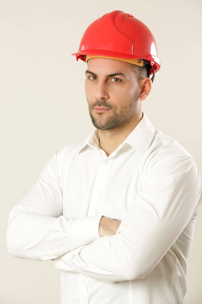 Студійний знімок молодого бізнесмена носить червоний шолом і білий
  - Фото, зображення