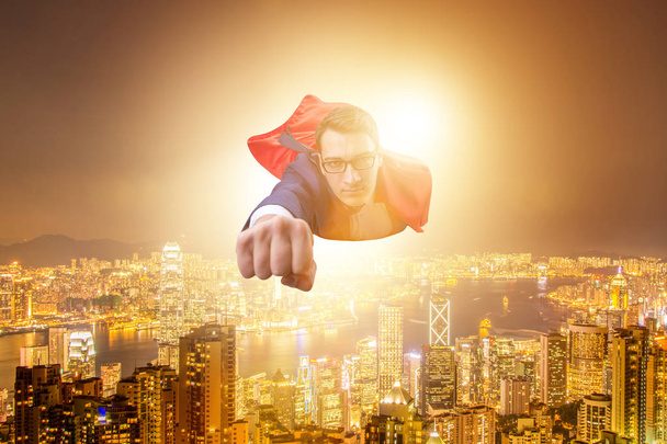 Superhéroe hombre de negocios volando sobre la ciudad
 - Foto, Imagen