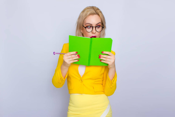 Portrait of blonde woman with books and pen - Φωτογραφία, εικόνα