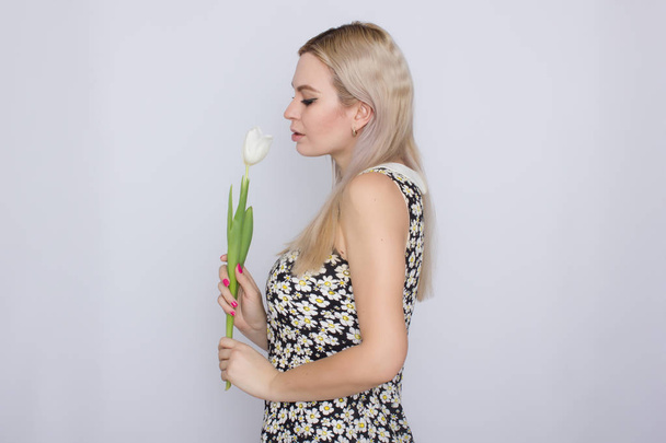 Blonde woman holding one white tulip - Foto, immagini