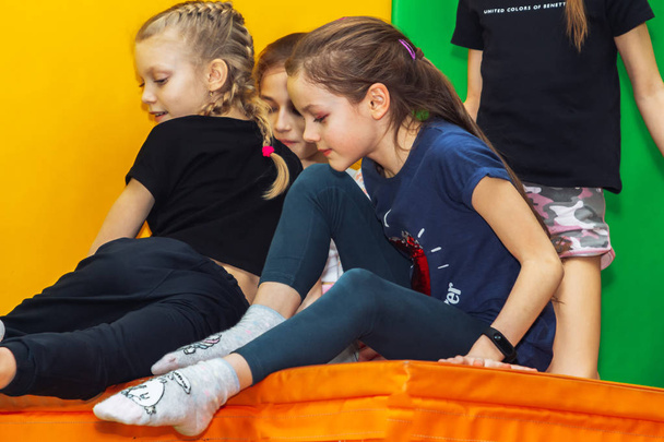 February 9, 2019 Minsk Belarus Training in the trampoline hall Little girls sit in the gym - Foto, Imagen