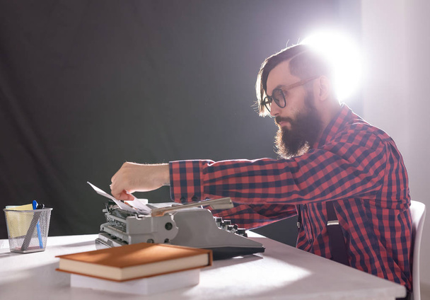 Menschen, Schriftsteller und Hipster-Konzept - junger stilvoller Schriftsteller arbeitet an Schreibmaschine - Foto, Bild