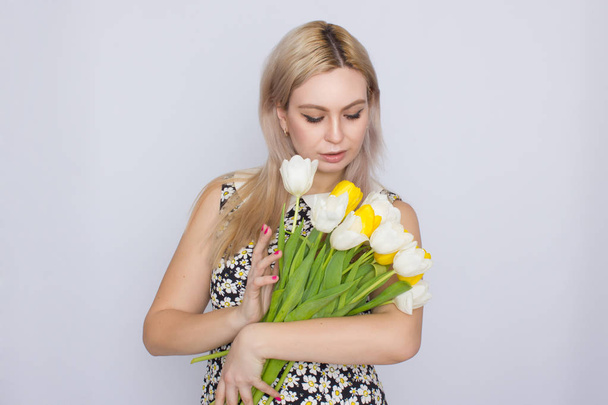 Blonde woman holding bouquet of tulips - Фото, изображение