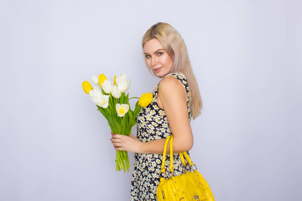 Blonde woman holding bouquet of tulips - Фото, зображення