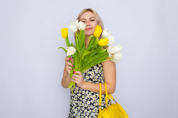 Blonde woman holding bouquet of tulips - Foto, imagen