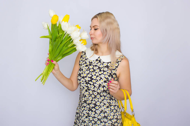 Blonde woman holding bouquet of tulips - Zdjęcie, obraz