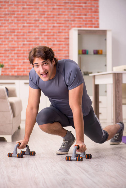 Young handsome man doing sport exercises at home  - Fotoğraf, Görsel