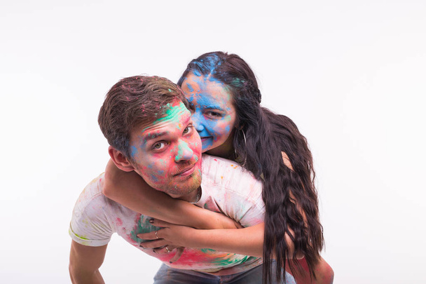 Φεστιβάλ holi, φιλίας και αστεία ιδέα - νέοι άνθρωποι που παίζουν με τα χρώματα στο Φεστιβάλ holi σε λευκό φόντο - Φωτογραφία, εικόνα
