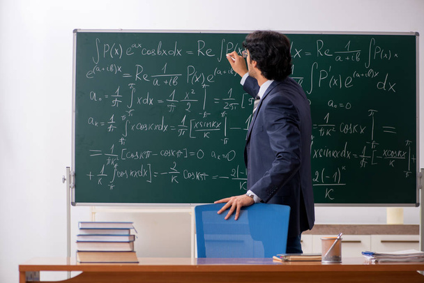 Jonge mannelijke wiskundeleraar in de klas  - Foto, afbeelding