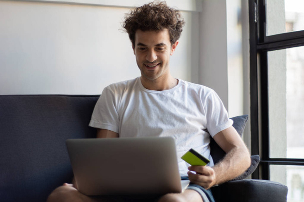 Man with laptop and credit card at home.  - Photo, Image
