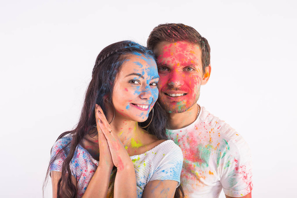 Festival of holi, friendship - young people playing with colors at the festival of holi on white background - Photo, Image