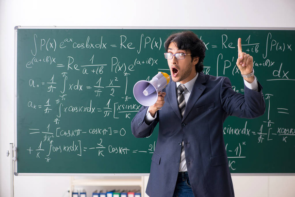 Νεαρά αρσενικά μαθηματικά δάσκαλος στην τάξη  - Φωτογραφία, εικόνα