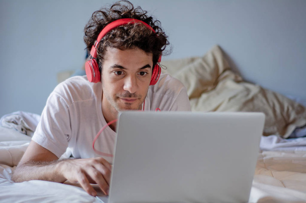Young man with headphones and using laptop - Foto, Imagen