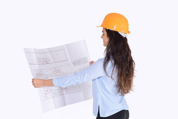 Female architect holding blueprint. - Foto, imagen